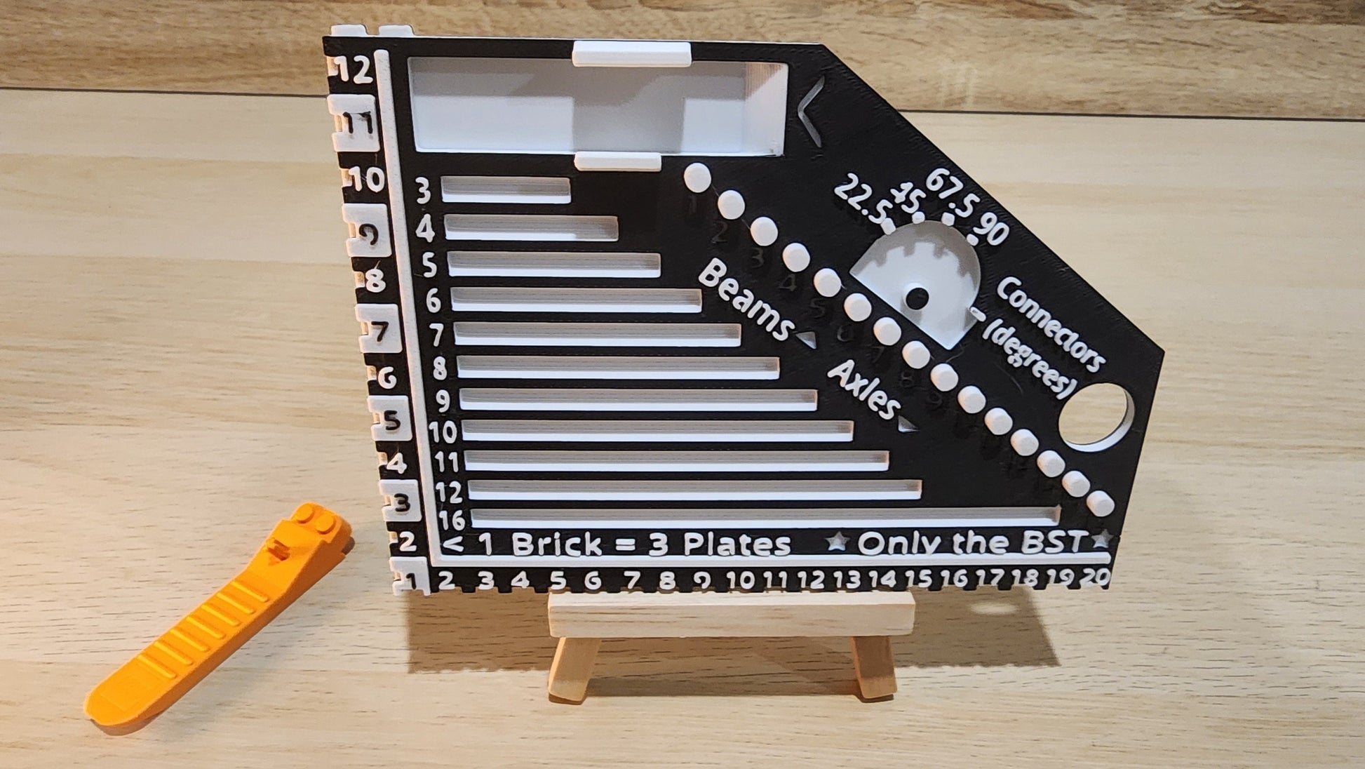 Black and white brick ruler with a brick separator next to the ruler.