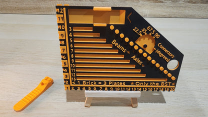 Black and orange brick ruler with a brick separator next to it.