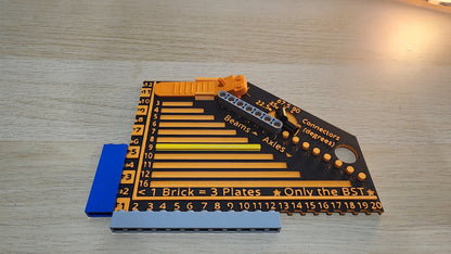 Black and orrange brick measuring ruler with some lego pieces on and around the ruler, Showing how it works.