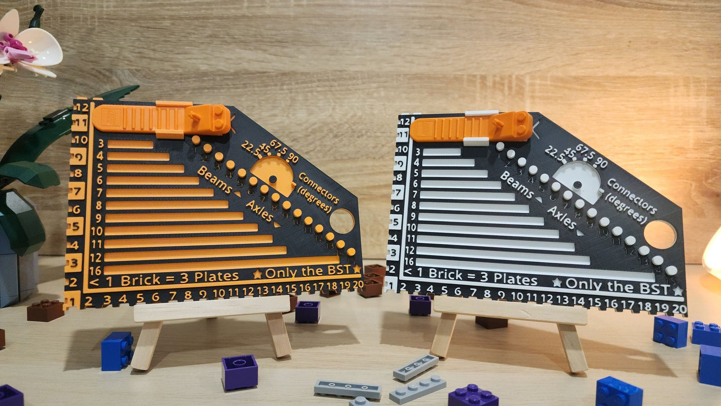 Two brick rulers next to each other. Black and orange on the left and the black and white on the right. There are some Lego pieces arround the brick rulers.