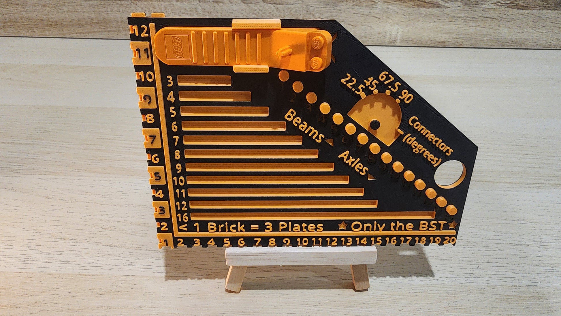 Black and orange brick ruler with a brick separator attached.