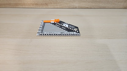 Black and White brick ruler with a brick separator attached showing the side view.
