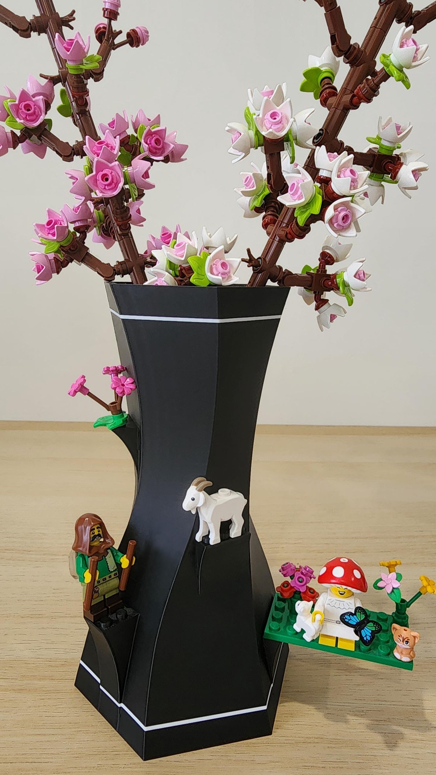 Close-up of black and white LEGO-Compatible Vase with white, pink LEGO flowers and other lego pieces attached