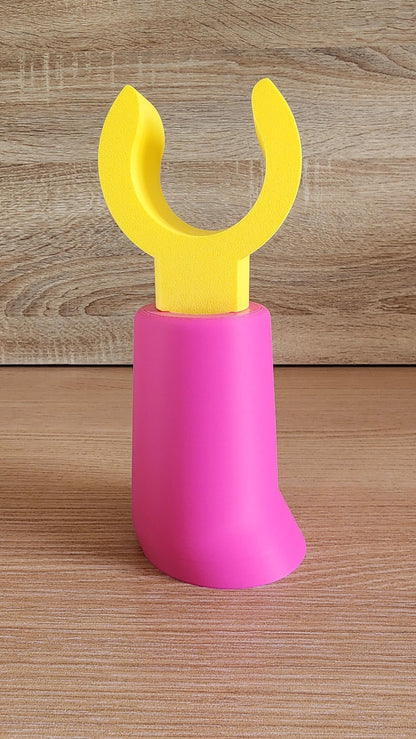 Pink and yellow Minifig-Inspired Headphone Holder on rustic wood surface